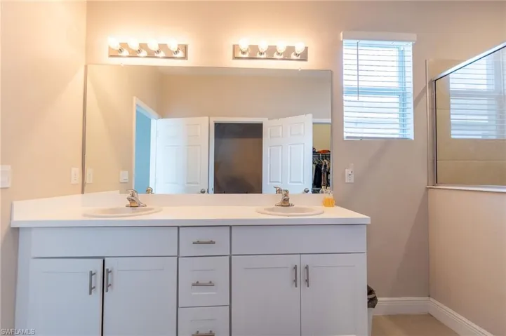 Full bathroom with double vanity and a shower with door