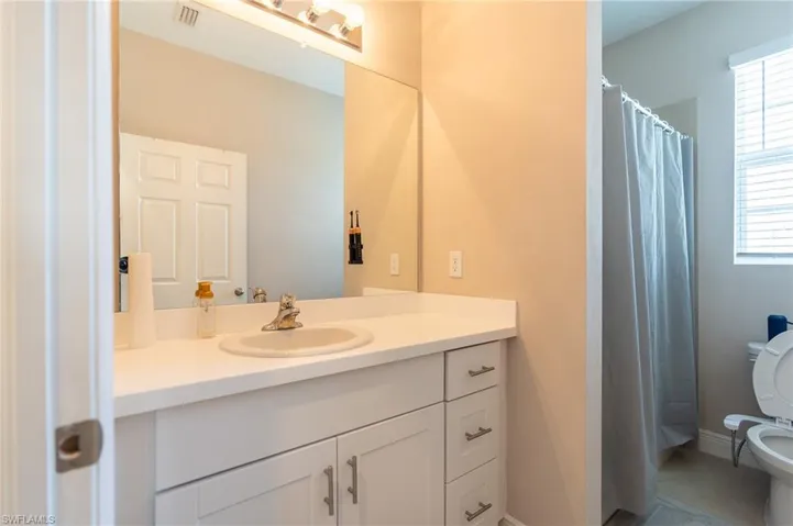 Full bath featuring a stall shower, healthy amount of natural light, and vanity