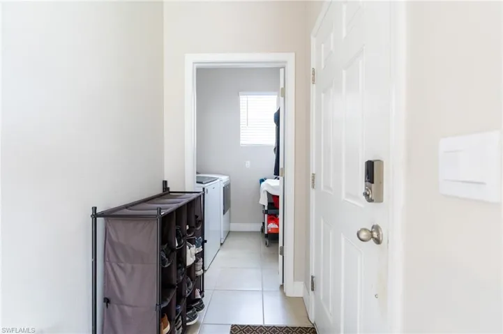 Laundry area with light tile patterned floors and independent washer and dryer