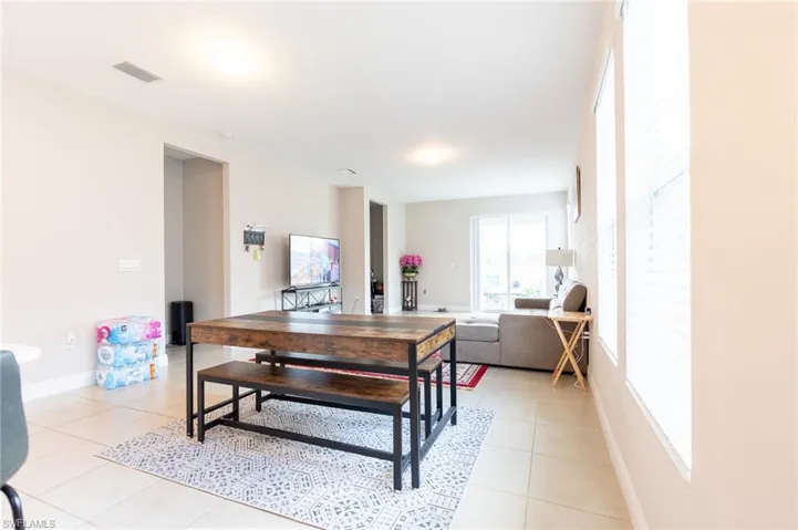 Dining area featuring light tile patterned floors and baseboards