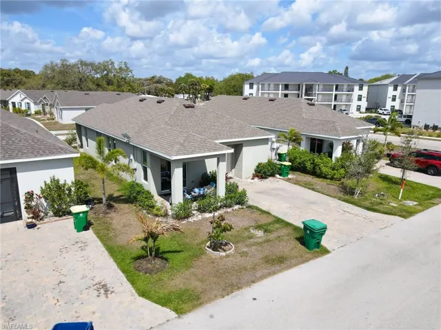 View of front of house with roof with shingles, stucco siding, driveway, and a residential view