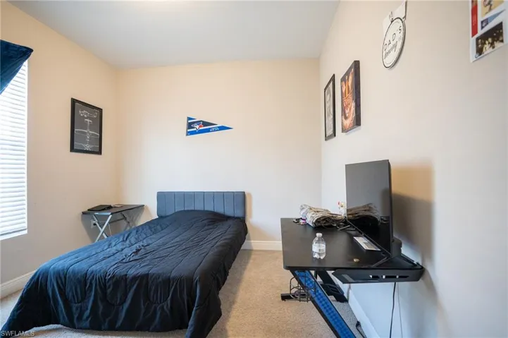 Bedroom featuring light colored carpet and baseboards