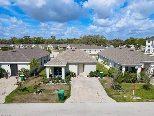 Ranch-style home with roof with shingles, stucco siding, a residential view, and driveway