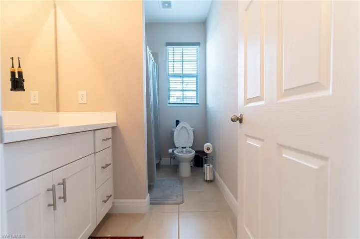 Bathroom with vanity, a shower with curtain, and light tile patterned floors