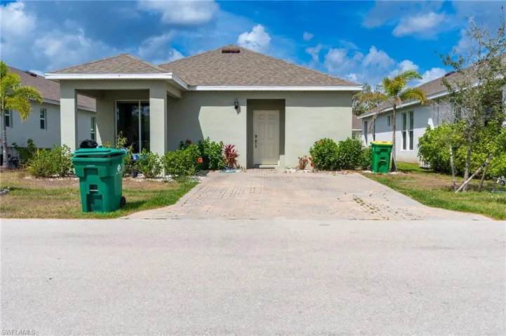 View of front of home with stucco siding and a shingled roof