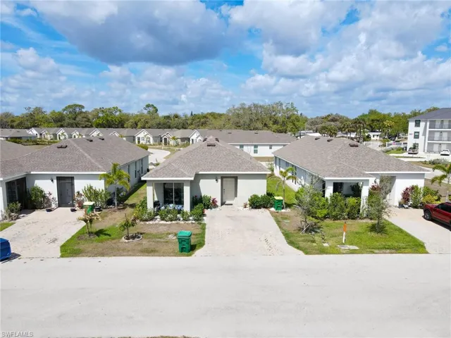 View of front of house featuring a residential view, a shingled roof, stucco siding, and driveway
