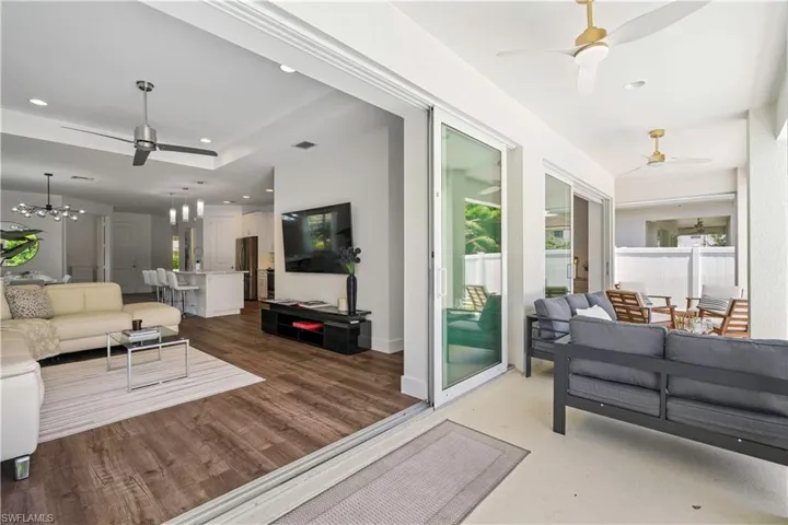 Living area featuring a ceiling fan, a chandelier, recessed lighting, and dark wood-style flooring