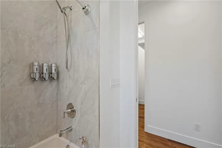 Full bathroom featuring shower / bathtub combination and dark wood-style floors
