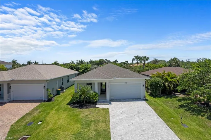 Ranch-style home featuring a front lawn, decorative driveway, a shingled roof, and an attached garage