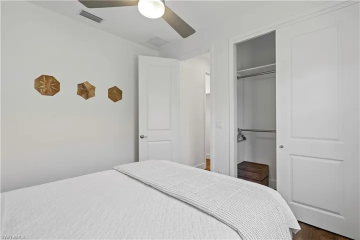 Bedroom featuring a ceiling fan, a closet, and dark wood-type flooring