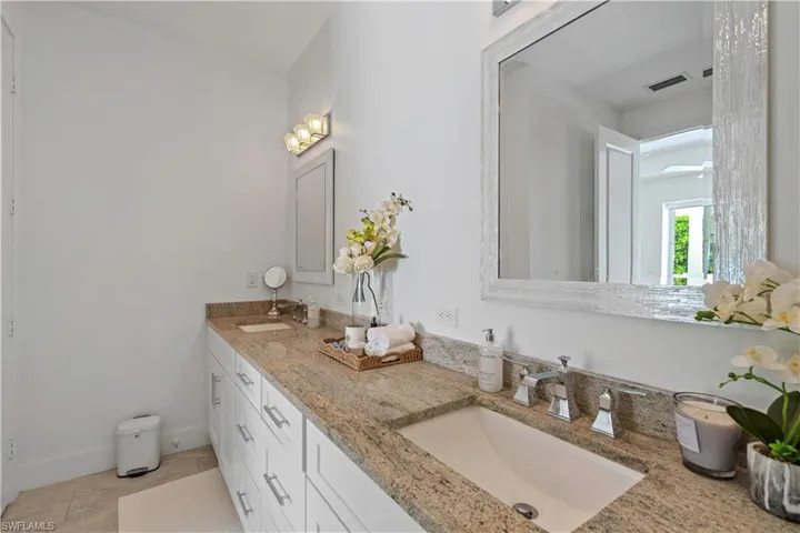 Bathroom with double vanity and light tile patterned floors