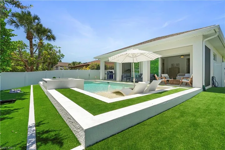 View of swimming pool featuring a fenced backyard, a patio, an outdoor hangout area, and a pool with connected hot tub