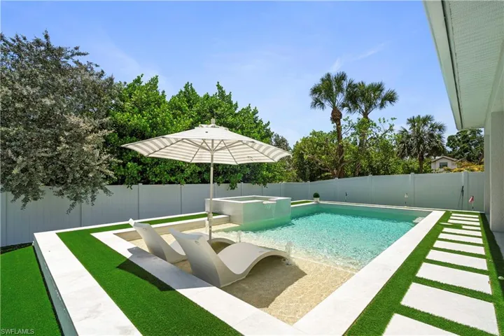 View of pool with a patio, a fenced backyard, and a pool with connected hot tub