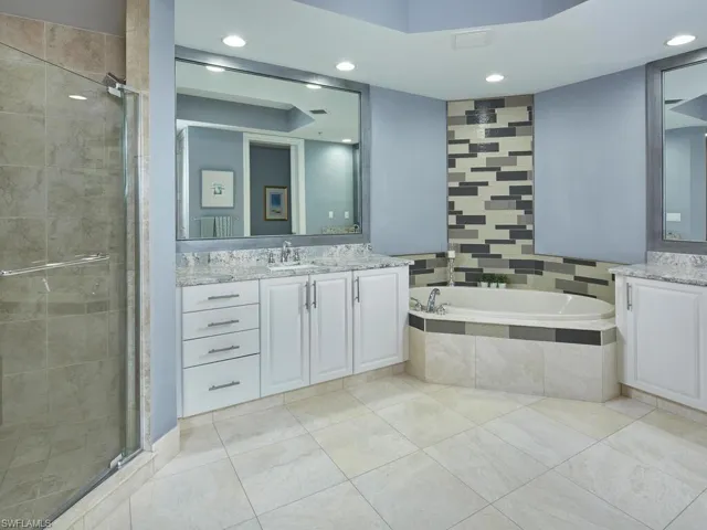 Primary bath with a soaking tub, a walk in shower, two separate vanity areas, and a TON of storage space.