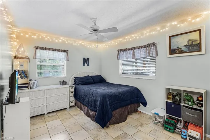 Bedroom with a textured ceiling and a ceiling fan