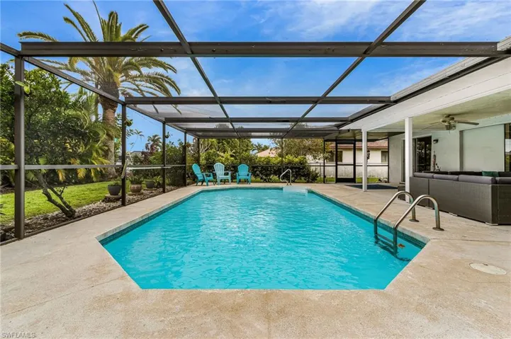 View of swimming pool with a sunroom, an outdoor hangout area, glass enclosure, and patio surround