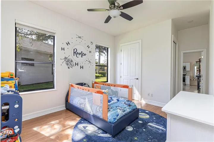 Bedroom featuring light hardwood / wood-style flooring, ceiling fan, and multiple windows