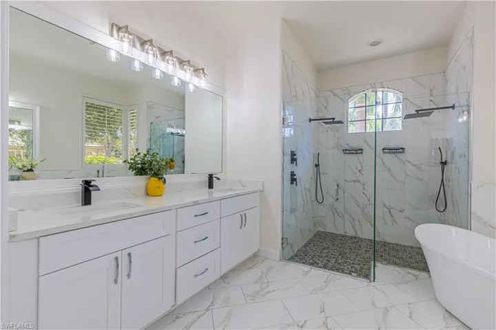 Bathroom with tile patterned floors, shower with separate bathtub, and dual bowl vanity