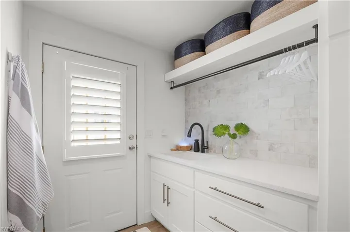 Custom cabinetry, quartz counters & utility sink