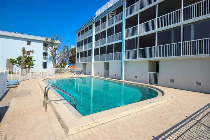 Community pool with fence and a patio area