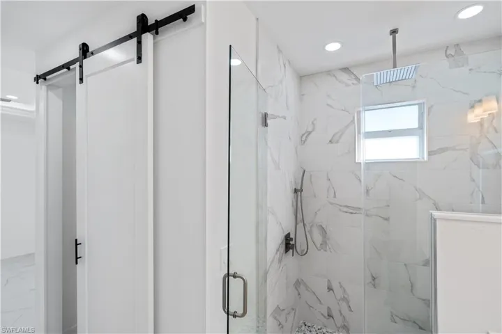Full bath featuring a marble finish shower and recessed lighting