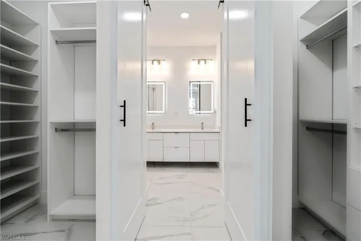 Walk in closet featuring elevator and light marble finish flooring