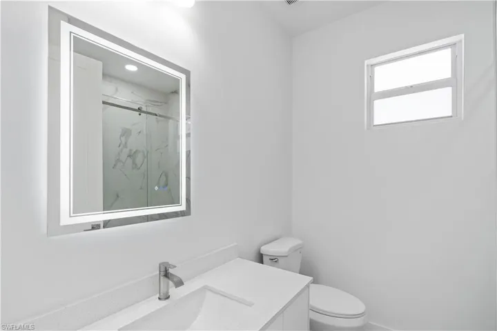 Full bathroom with a marble finish shower and vanity
