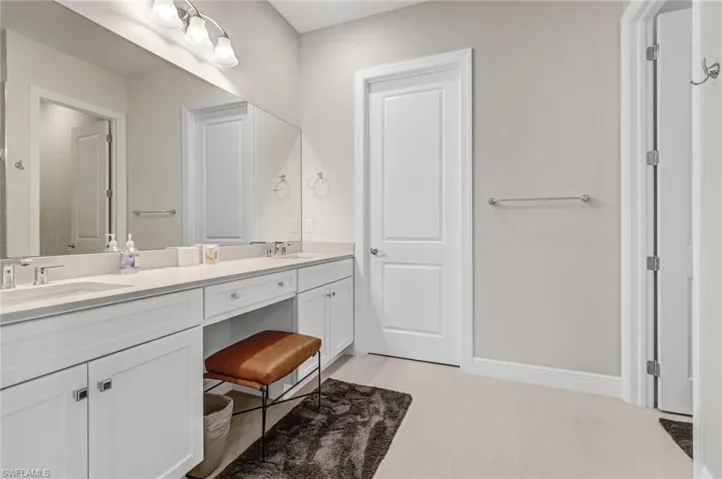 Bathroom featuring a sink, baseboards, double vanity, and tile patterned flooring