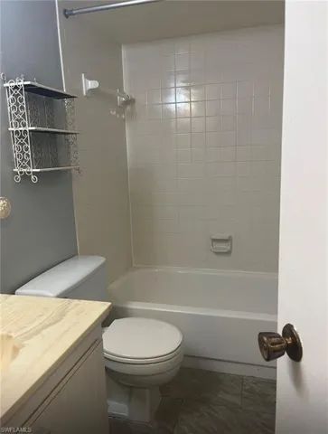 Full bath featuring vanity, bathtub / shower combination, and tile patterned flooring