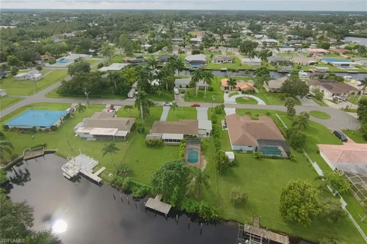 Waterfront property with boat dock, inground pool, and mature landscaping
