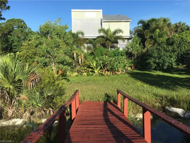 Back of house, back yard  with bridge over pond.