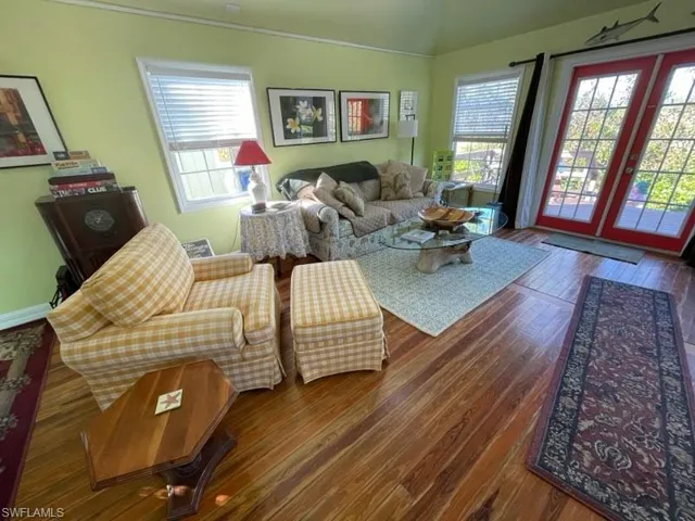 Living room of rental cottage with french doors, plenty of natural light, and wood floors.
