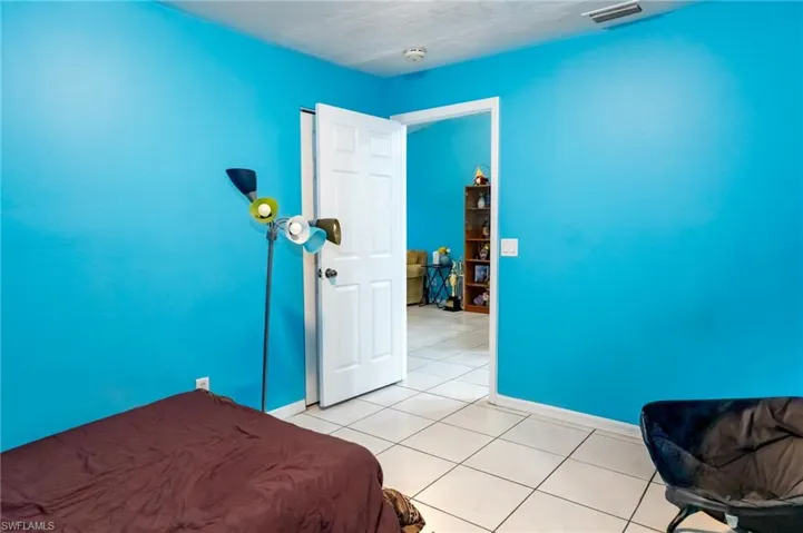 Bedroom featuring tile patterned flooring and baseboards