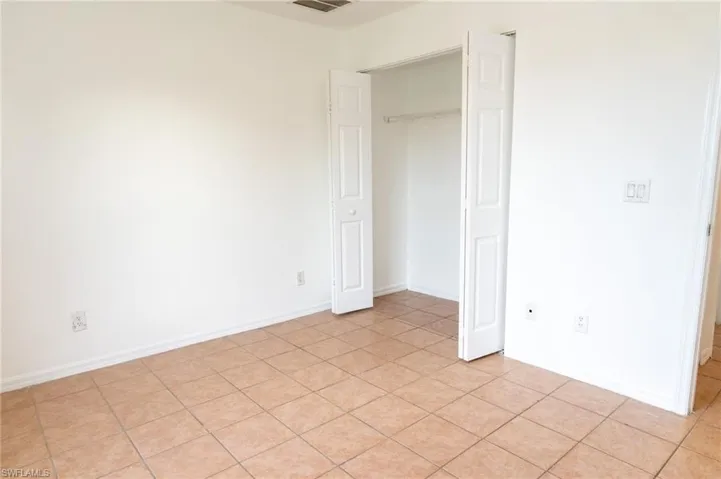 Unfurnished bedroom featuring light tile patterned floors and a closet