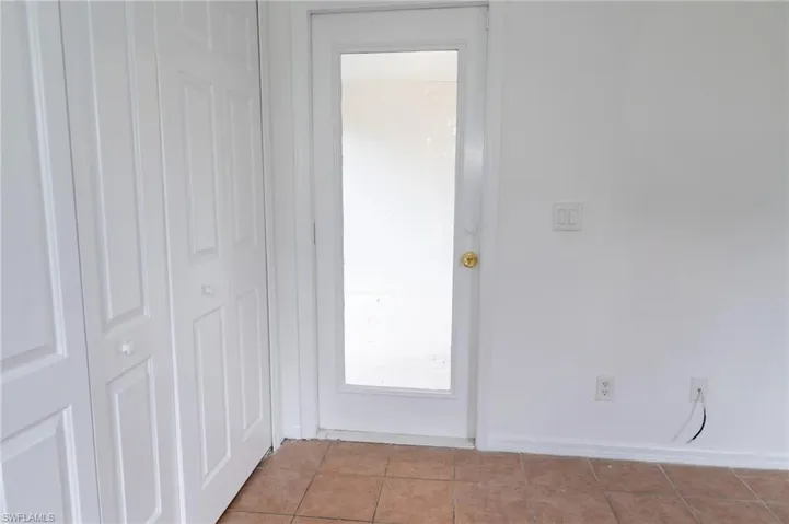 Doorway to outside with tile patterned floors and baseboards