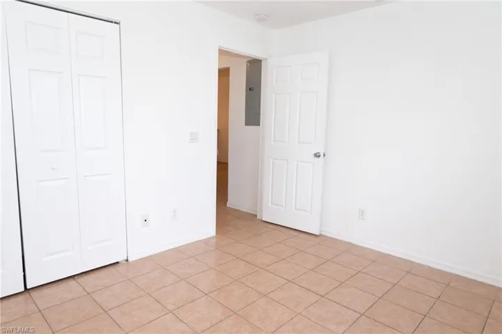 Unfurnished bedroom featuring light tile patterned flooring and a closet