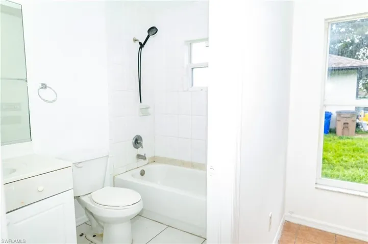 Full bath with shower / bath combination, vanity, and light tile patterned flooring