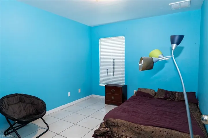 Bedroom featuring light tile patterned floors and baseboards