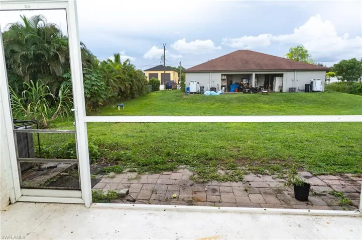Back of house with a patio and a lawn