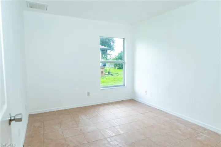 Empty room featuring baseboards and light tile patterned floors