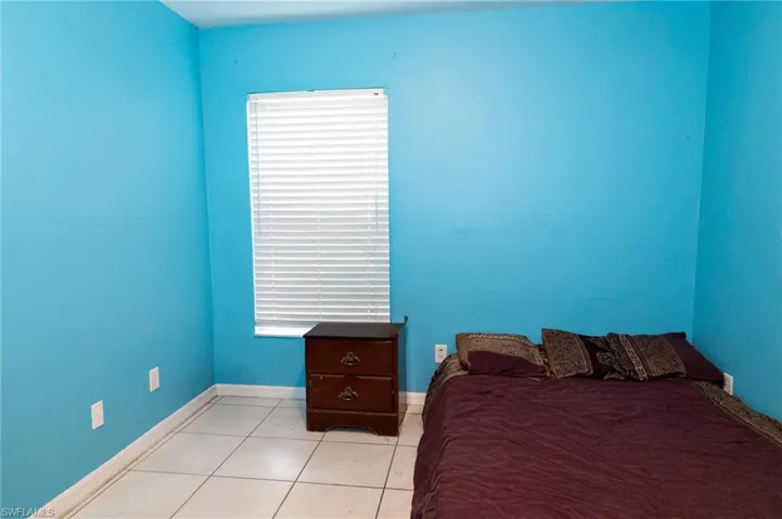 Bedroom with tile patterned flooring and baseboards