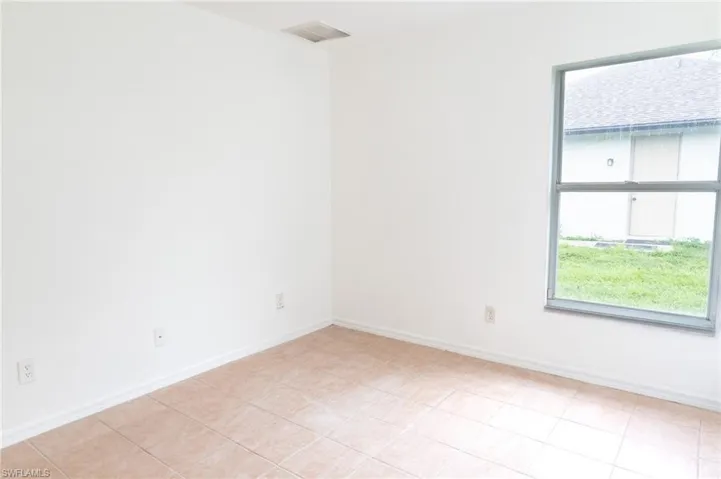 Empty room with baseboards and light tile patterned flooring