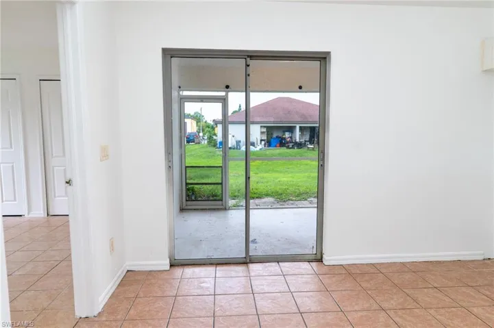 Doorway with tile patterned floors and baseboards
