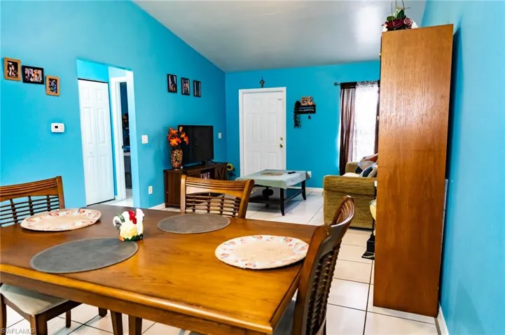 Dining area featuring light tile patterned flooring and lofted ceiling