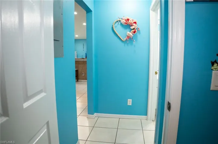 Hallway featuring light tile patterned flooring and baseboards