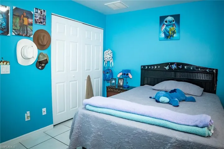 Tiled bedroom featuring a closet and baseboards