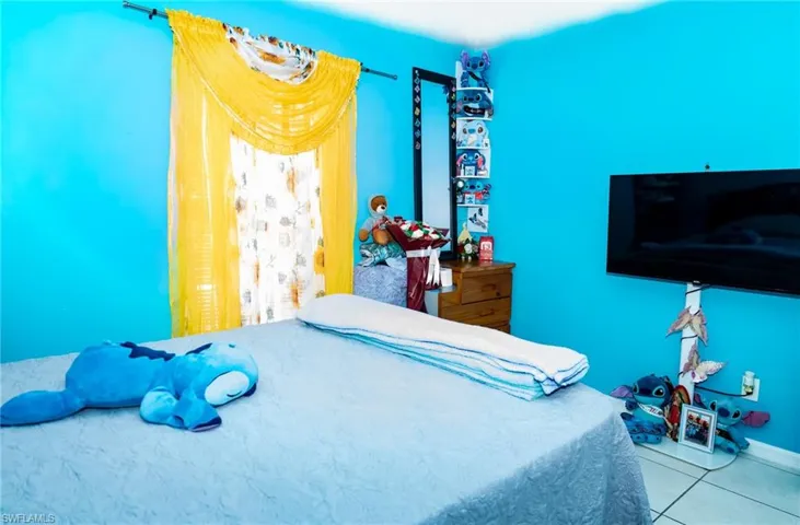 Tiled bedroom featuring baseboards