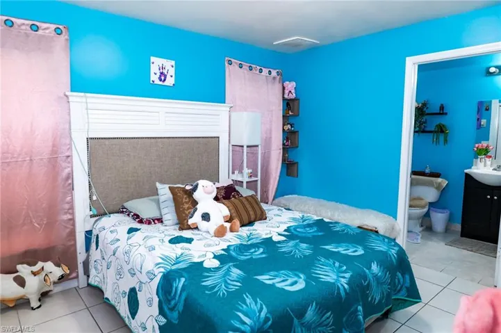 Bedroom featuring tile patterned flooring and ensuite bath