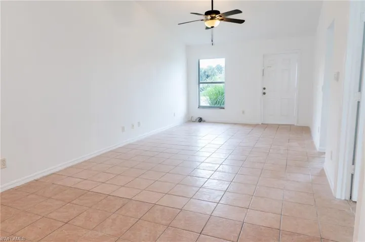 Spare room with light tile patterned floors and a ceiling fan
