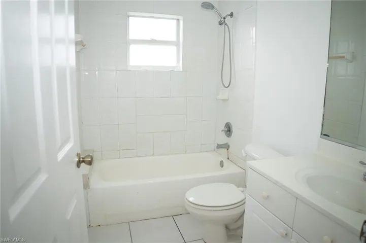 Bathroom featuring  shower combination, vanity, and light tile patterned floors
